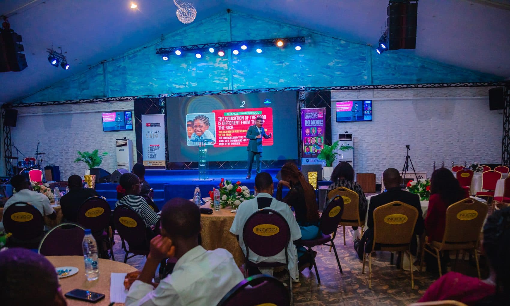 Delegates seated at tables facing the stage during a Leadership Rebirth Conference session