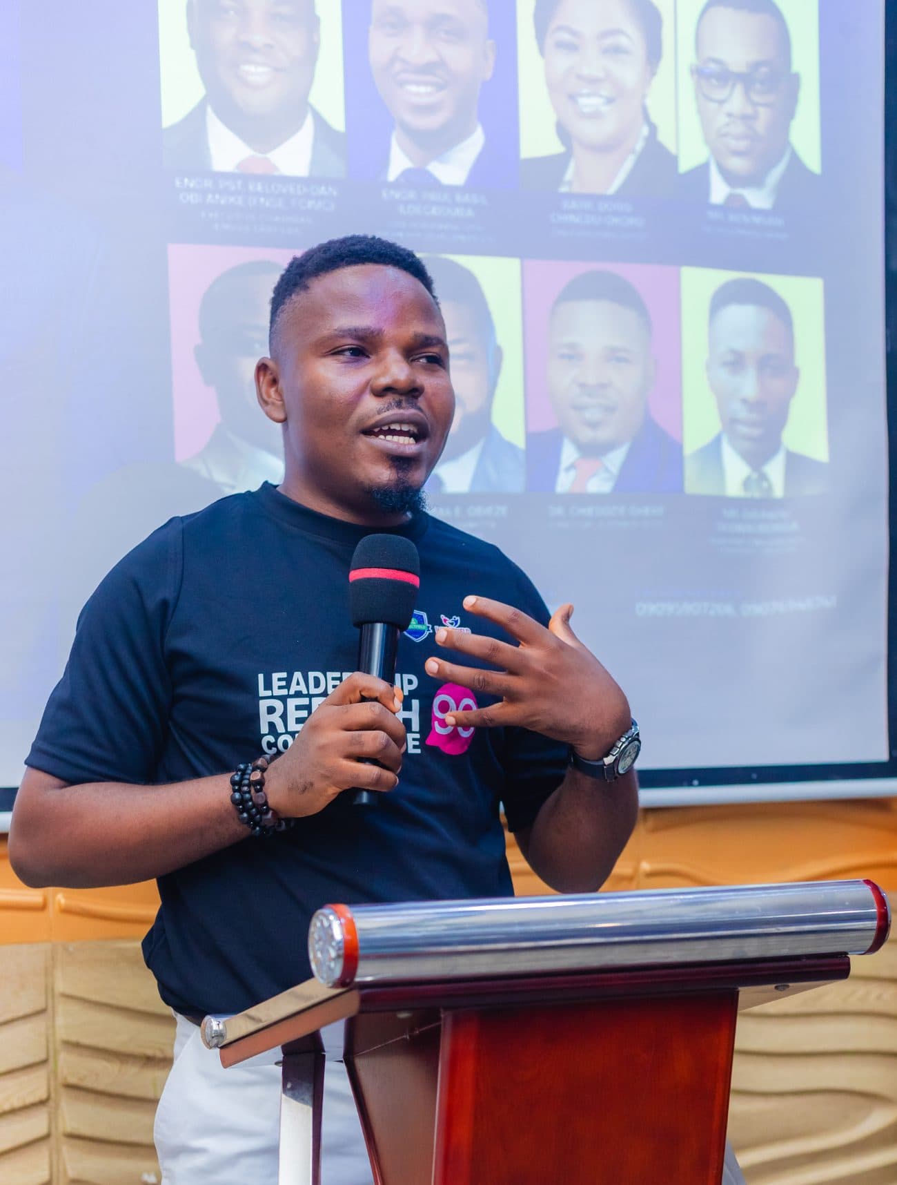 A delegate speaking into a microphone at the podium during a Leadership Rebirth Conference session